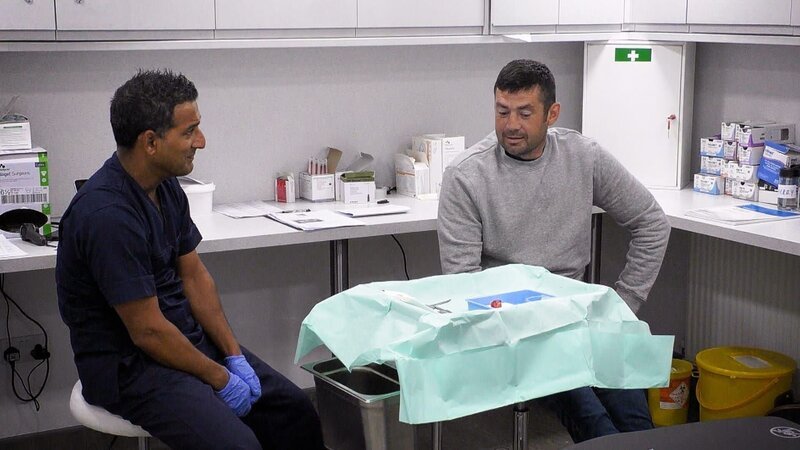 Dermatologe (Dev Shah, l.) bespricht etwas mit einem Patienten. – Bild: TLC