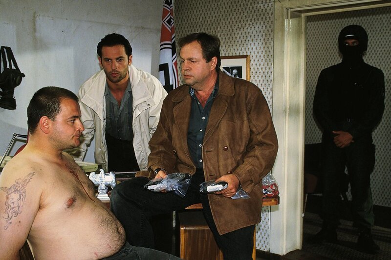 Die Kommissare Kehler (Wolfgang Bathke, r.) und Eschenbach (Matthias Bullach, M.) verhören den Neonazi Prolla (Michael Trischan), der des Mordes verdächtigt wird. – Bild: RTL