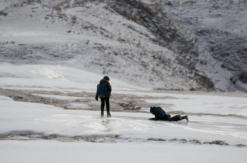 Sherali (re.) und Ali Sayakov (li.) müssen im Winter immer wieder gefährliche, eisglatte Stellen überqueren. – Bild: Axel Funck /​ Maximus Film