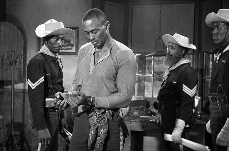 Sergeant Braxton Rutledge (Woody Strode, 2.v.l.) wird allein am Tatort angetroffen und von den Soldaten festgenommen. – Bild: Warner Bros.