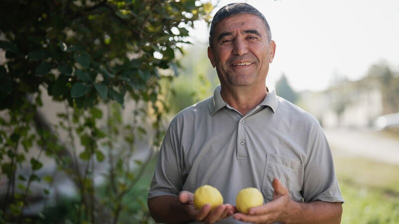 Zu Tisch Usbekistan Bahriddin zeigt stolz seine Quitten – Bild: SRF/​Berlin Producers Media/​Dunja Engelbrecht
