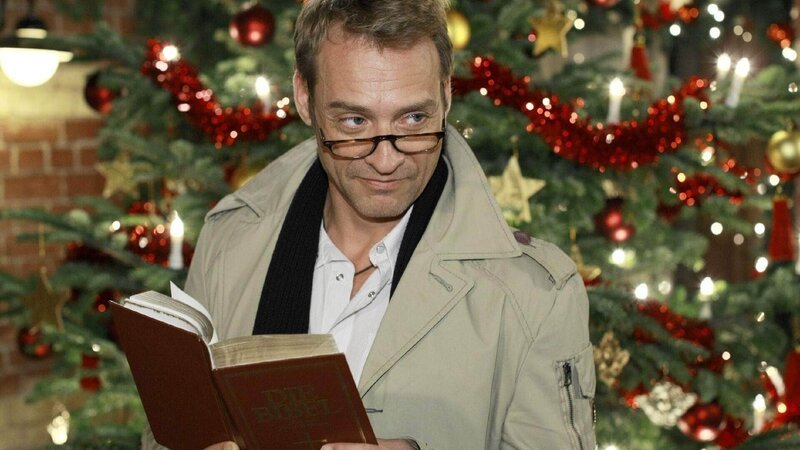 Rufus (Kai Noll) liest für die Bewohner der Schillerallee die Weihnachtsgeschichte. – Bild: TVNOW /​ Guido Engels