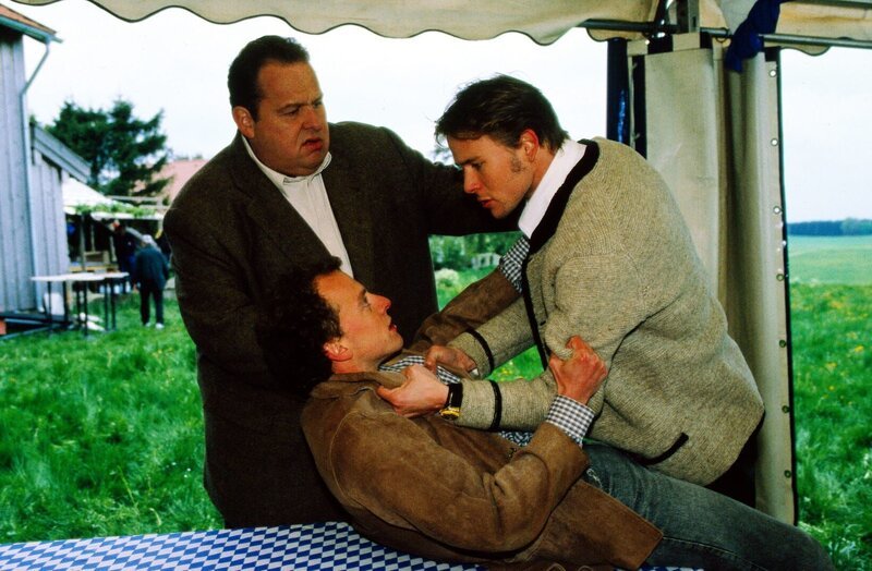 Hans Korndorfer (Philipp Brammer) wird von Florian Auracher (Oliver Clemens) angegriffen. Benno Berghammer (Ottfried Fischer) kann die Streithähne gerade noch rechtzeitig trennen. – Bild: SAT.1 /​ Magdalena Mate