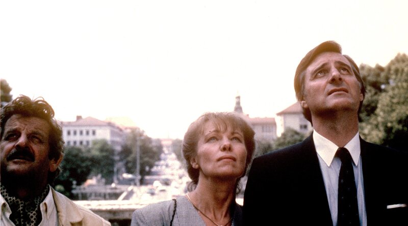 „Monaco Franze“, „Der Friedensengel.“ Vor Jahren hatte Monaco eine flüchtige Affäre mit einer jungen Schweizer Dame, die ihn offensichtlich nie vergessen hat. Ihre Wiedersehensfreude wird von zwei Tatsachen ein wenig getrübt: Monaco ist glücklich verheiratet und die Dame kommt in Begleitung ihres Mannes. Im Bild (v.li.): Walo Lüönd (Hubert Mitteregger), Hilde Ziegler (Carola Mitteregger), Helmut Fischer (Monaco Franze). – Bild: ORF/​TELEPOOL