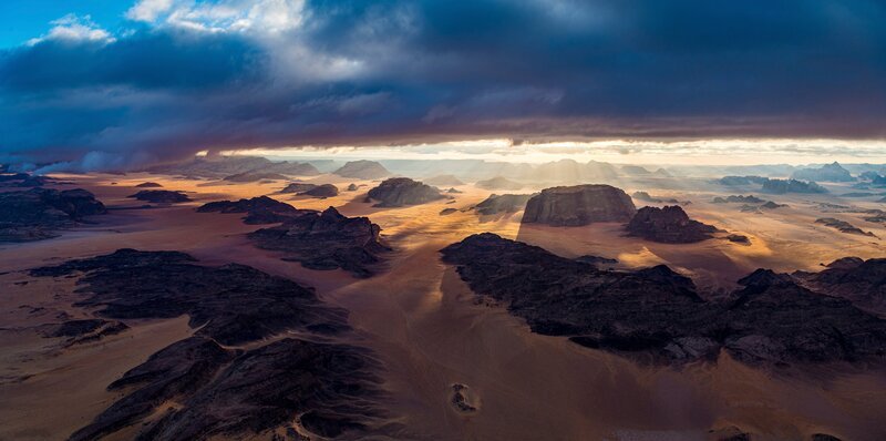 Kamel mit gefiederten Belgleitern im abendlichen Wadi Rum-Tal in Jordanien. Das Wadi Rum-Schutzgebiet in Jordanien gehört zum Weltnaturerbe der UNESCO. – Bild: BR/​Michael Martin