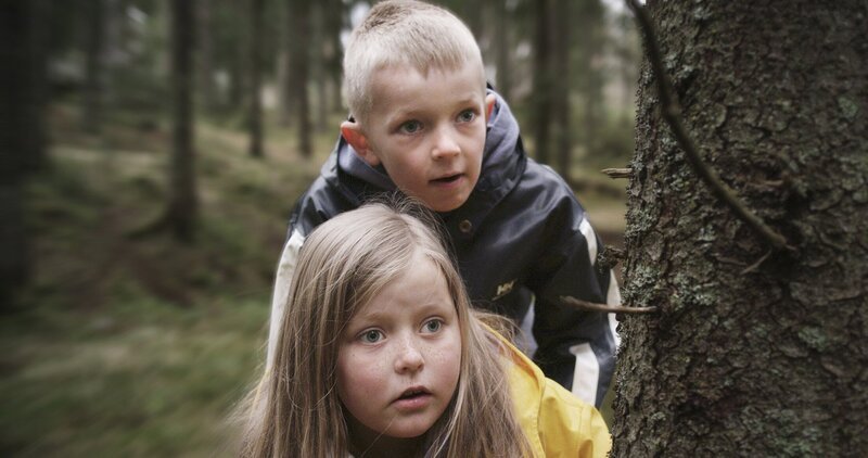 Robin (Erlend Böe) und Kaja (Synne Stensgård) beobachten, wie im Wald ein Gewehr versteckt wird. – Bild: NDR/​NordicStories