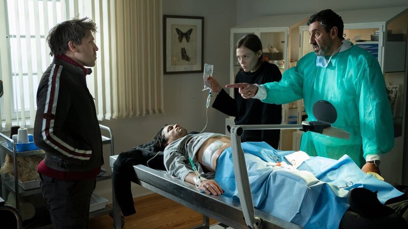 Mo (Hanno Koffler) besucht seinen nach dem Überfall den schwer verletzten Bruder Lucca (Doga Gürer), der von Doc Matar (Raymond Tarabay) und Sybill (Paula Kober) versorgt wird. – Bild: ZDF und Georges Pauly