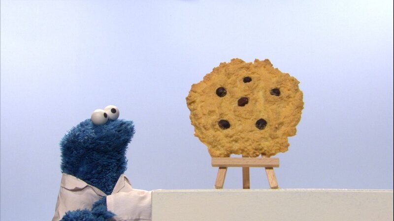 Krümel entdeckt, dass ein kleiner Keks ganz groß erscheinen kann. Lecker! – Bild: NDR/​Studio Hamburg Produktion/​Sesame workshop