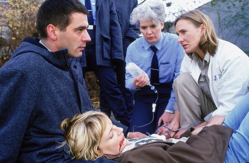 Mareike (Sanna Englund, lieg.) wurde von Andys Kugel getroffen. Hendrik (Ulrich Drewes, li.), Birgit (Uta Prelle, Mi.) und Kerstin (Meike Schlüter, re.) versuchen noch zu helfen … – Bild: RTL