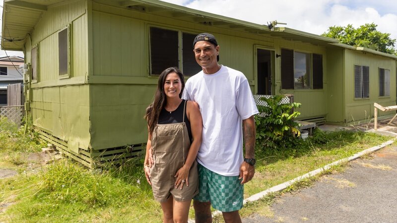 Tristyn and Kamohai Kamala posed in front of exterior of green house on Kalama Compound as seen on Renovation Aloha, Season 2 – Bild: Warner Bros. Discovery, Inc. or its subsidiaries and affiliates /​ Nani Welch Keliihoomalu