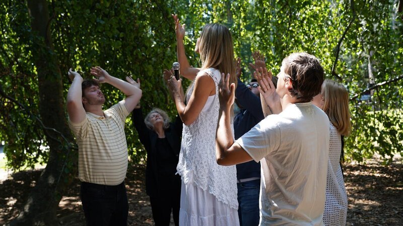 Recreation of Sheryl Ruthven and followers congregating in woods – Bild: Warner Bros. Discovery, Inc. or its subsidiaries and affiliates