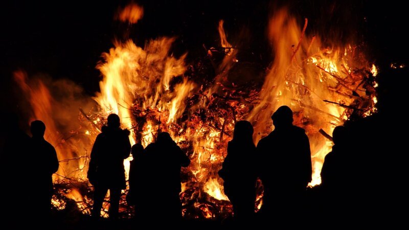 Silhouette von Menschen vor einem Lagerfeuer – Bild: GettyImages