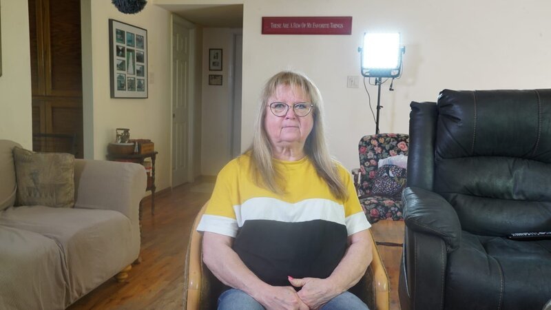 Jacqueline Young sits in the living room for a picture with her hands clasped in her lap. A bright light can be seen behind her. – Bild: Warner Bros. Discovery, Inc. or its subsidiaries and affiliates. All rights reserved.