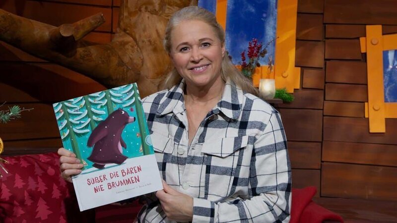 Singa liest ein Buch vor, in dem einem Bären im verschneiten Wald ein Missgeschick passiert. Schafft er es rechtzeitig zu Weihnachten nach Hause? – Bild: KiKA