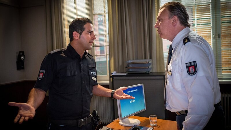 Nachdem auch Tarik (Serhat Cokgezen, l.) einen anonymen Anruf bekommen hat, möchte er von Haller (Hannes Hellmann, r.) wissen, worum es in Kims Disziplinarverfahren geht. – Bild: Boris Laewen