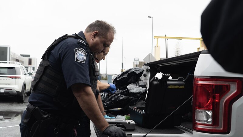 Die CBP-Beamten Knox und Ryan untersuchen den Inhalt einer zerbrochenen Styropor-Kühlbox, die auf der Ladefläche eines Lastwagens gefunden wurde, der über den JFK-Flughafen in New York City, N.Y., verschifft wurde. – Bild: NGC NETWORK US, LLC