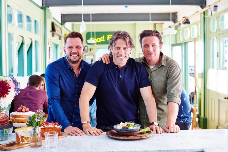 „Jamie & Jimmy’s Food Fight Club“, „Vegetarische Lasagne mit John Bishop.“ John Bishop, einer der beliebtesten Comedians Großbritanniens, ist bei Jamie und Jimmy am Southend Pier zu Gast. Jamie bereitet mit ihm ein verführerisches, grünes Thai-Curry zu und präsentiert sein Rezept für die beste vegetarische Lasagne der Welt. Während John im Restaurant aufkocht, überlegen sich Jamie und Jimmy, wie Kinder auch in der Ferienzeit ausreichend mit gesundem Essen versorgt werden können.Im Bild (v.li.): Jimmy Doherty, John Bishop, Jamie Oliver. – Bild: RTL Living /​ ©2016 Jamie O