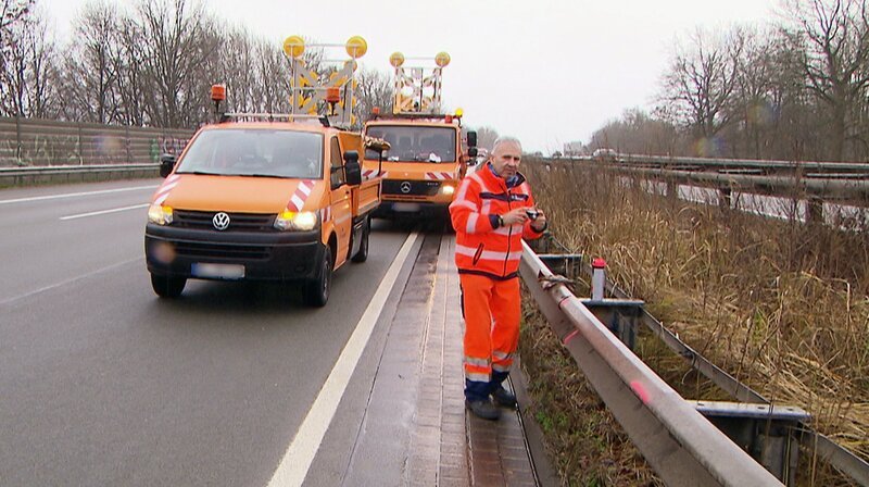 Streckenwart Ralf Kahnke beim Dokumentieren eines Unfallschadens an einer Leitplanke. – Bild: NDR/​MfG-Film GmbH und CoKG/​Ralf Biehler