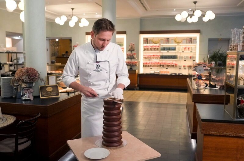 Konditormeister Julian Kübel schneidet einen Baumkuchen in dünne Scheiben. – Bild: SWR