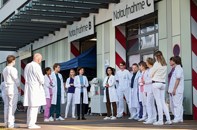 Nach einem Massenunfall werden mehrere Patienten am Johannes-Thal-Klinikum erwartet. Karin Patzelt und Leyla Sherbaz geben ihrem Team Anweisungen. V.l.n.r.: Komparasin, Komparse, Emma Jahn (Elias Agbaglah), Mikko Rantala (Luan Gummich), Komparsin, Karin Patzelt (Marijam Agischewa), Leyla Sherbaz (Sanam Afrashteh) und Komparsen. – Bild: ARD/​Jens Ulrich Koch