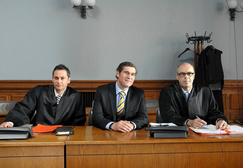 Flankiert von seinen Anwälten Braun (Peter Kremer, re.) und Rigas (Vassily Kazakos, li.) gibt der angeklagte Bürgermeisterkandidat René Tornow (Stephan Szasz) sich siegesgewiss. – Bild: ARD Degeto/​Susan R. Skelton