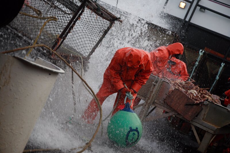 Neal Hillstrand takes a wave, Eddie Uwekoolani in background looking on. – Bild: Discovery