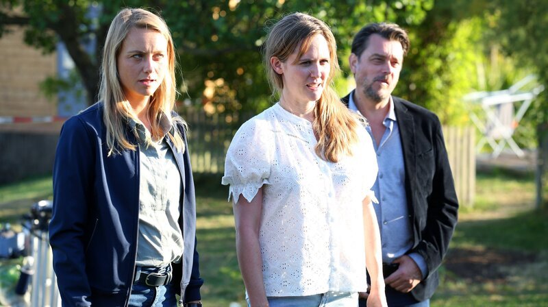 Kommissar Bergmann (Hary Prinz, re.) und seine Partnerin Anni (Anna Unterberger, li.) sprechen mit Jana Skoff (Emily Cox, Mitte). – Bild: ARD Degeto/​Allegro Film/​Stefan Haring