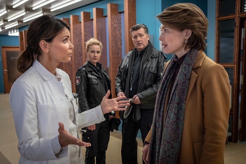 Birgit Kirsch (Sonja Baum, r.) ist überrascht, als Dr. Jonas (Gerit Kling, l.) ihr erzählt, dass sich ihre Tochter bei einem Sturz auf einer Party verletzt hat. (Franzi: Rhea Harder-Vennewald, 2.v.l., Hans: Bruno F. Apitz, 2.v.r.) – Bild: ZDF/​Boris Laewen (bola)