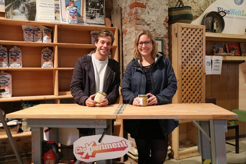 Checker Tobi und Psychologin Verena vor dem Verkaufsstand – Bild: BR/​megaherz gmbH/​Hans-Florian Hopfner