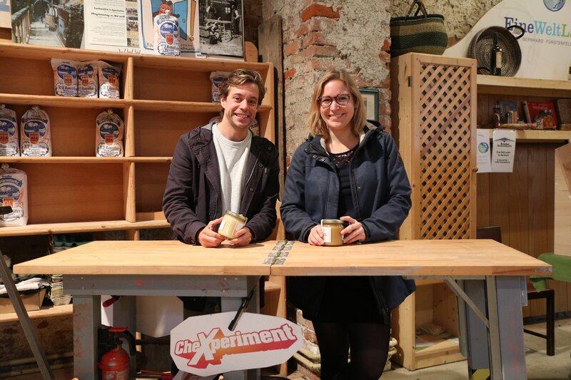 Checker Tobi und Psychologin Verena vor dem Verkaufsstand – Bild: BR/​megaherz gmbH/​Hans-Florian Hopfner