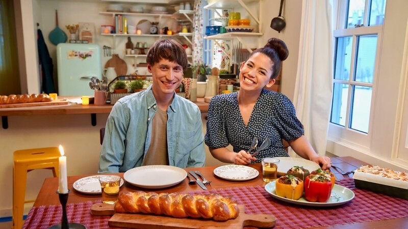Portrait shot of Molly Yeh and her husband Nick sitting down to eat Molly’s Orange Juice Challah, Shawarma Stuffed Peppers, and Gingersnap Coconut Icebox Cake, as seen on Girl Meets Farm, Season 7. – Bild: Discovery, Inc.