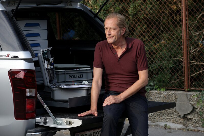 Wohlfahrt vor dem Tatort. (Spurensicherer Franz Wohlfahrt (Helmut Bohatsch)).  „SOKO Wien – Der falsche Mann“: Wohlfahrt wartet auf Informationen.  Fotograf: Stefan Haring – Bild: Bavaria Media GmbH /​ Die Verwendung ist nur bei redaktioneller Berichterstattung im Rahmen einer Programmankündigung ab 2 Monate vor der ersten Auss /​ © Bavaria Media