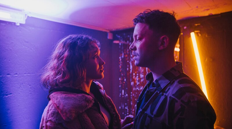 Sie treffen sich im Hinterzimmer seines Clubs: Betty Höpken (links, Mathilda Smidt) und Mike Hanisch (rechts, Niklas Marian Müller). – Bild: Radio Bremen/​Magdalena Stengel