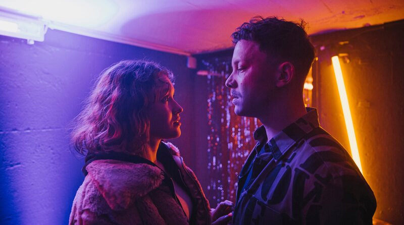 Sie treffen sich im Hinterzimmer seines Clubs: Betty Höpken (links, Mathilda Smidt) und Mike Hanisch (rechts, Niklas Marian Müller). – Bild: Radio Bremen/​Magdalena Stengel