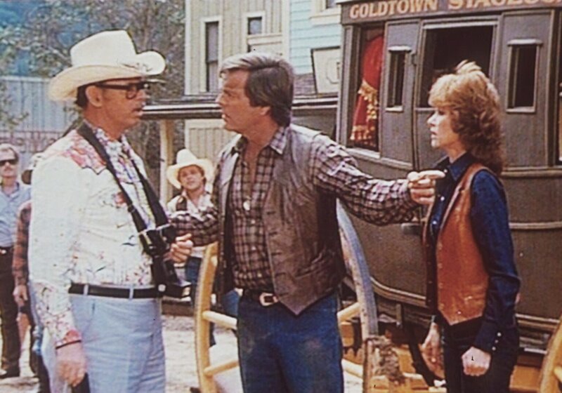 Jonathan (Robert Wagner, M.) und Jennifer (Stefannie Powers, r.) erklären einem Touristen, dass dieser mit der Postkutsche von Goldtown ganz schnell die Polizei holen soll … – Bild: Columbia Pictures