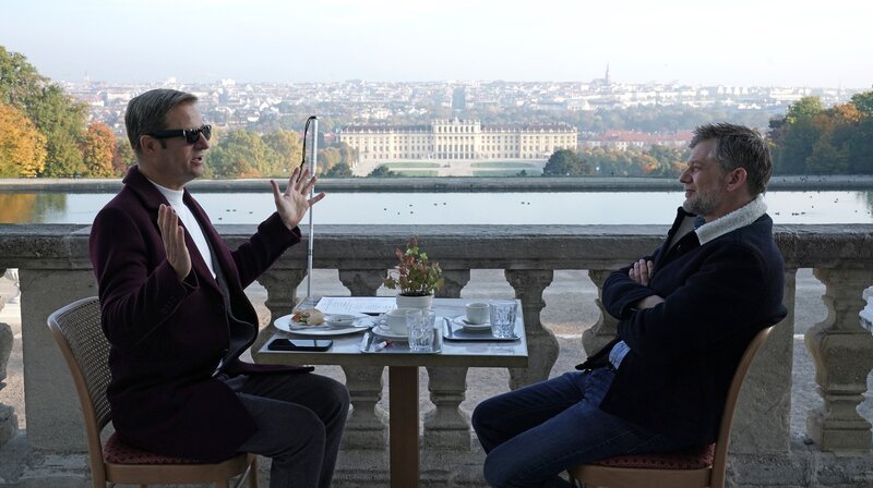 Ex-Kommissar Haller (Philipp Hochmair, li.) und Niko (Andreas Guenther) beim Frühstück mit herrlichem Blick über Wien. – Bild: ARD Degeto/​Mona Film/​Tivoli Film/​Petro Domenigg