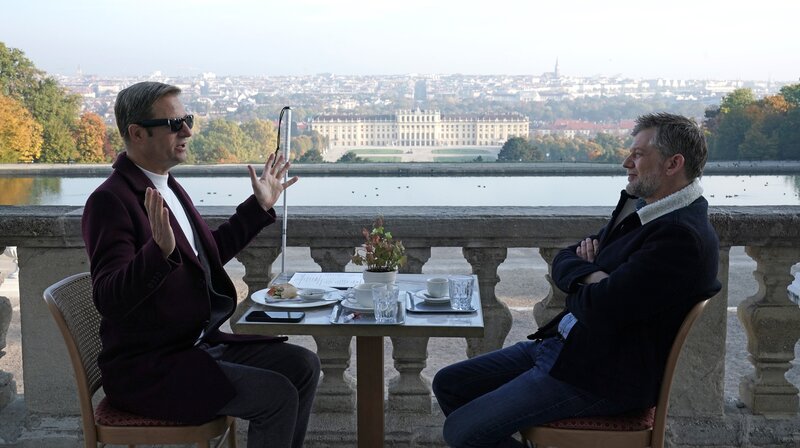 Ex-Kommissar Haller (Philipp Hochmair, li.) und Niko (Andreas Guenther) beim Frühstück mit herrlichem Blick über Wien. – Bild: ARD Degeto/​Mona Film/​Tivoli Film/​Petro Domenigg