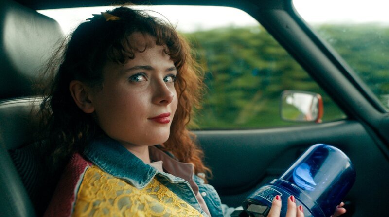 Zoe (Leia Murphy) im Polizeiauto. – Bild: WDR/​Deadpan Pictures/​Madeline Mulqueen