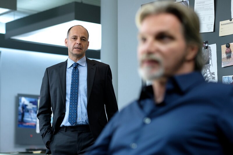 Dr. Seiler und Ribarski sprechen über ihren Fall am Attersee. (v.h.n.v.:  Dr. Seiler (Paul Matic), Major Carl Ribarski (Stefan Jürgens)).  „SOKO Wien – Ein hoher Preis“: Dr. Seiler und Ribarski im Büro.  Fotograf: Petro Domenigg – Bild: Bavaria Media GmbH /​ Die Verwendung ist nur bei redaktioneller Berichterstattung im Rahmen einer Programmankündigung ab 2 Monate vor der ersten Auss /​ © Bavaria Media