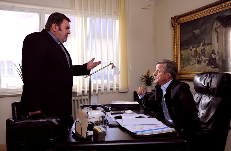 Bürgermeister Schattenhofer ist angefressen, weil Alois nicht zu dem verabredeten Termin gekommen ist. Von links: Pfarrer Neuner (Peter Rappenglück) und Bürgermeister Schattenhofer (Werner Rom). – Bild: Marco Orlando Pichler /​ BR /​ BR/​Marco Orlando Pichler