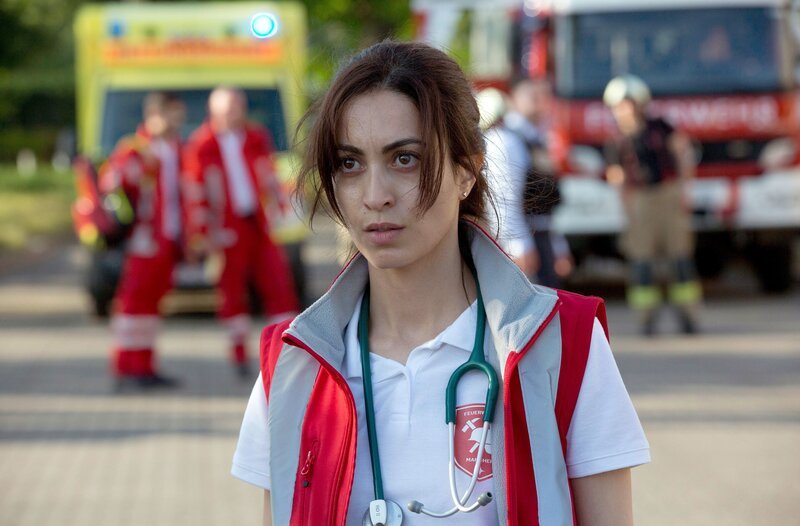 Ein Fahrer steckt mit seinem Kombi fest. Nina (Sabrina Amali) untersucht ihn und bricht auf dem Weg zum RTW zusammen. – Bild: ARD/​Volker Roloff