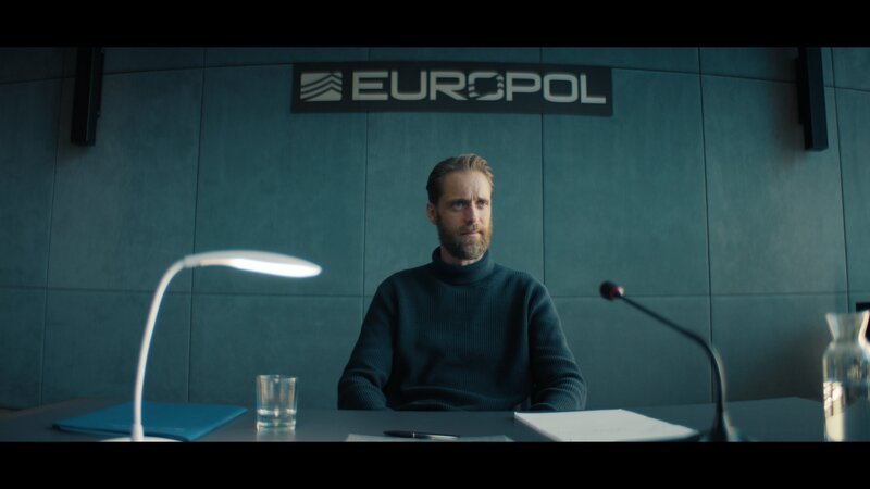 Benjo Brock (Bernd-Christian Althoff) sagt bei EUROPOL gegen OneCoin aus. – Bild: ZDF und Felix Poplawski