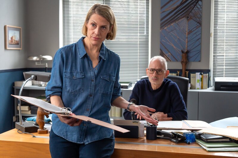 Tamara Meurer (Anja Pahl) und Kriminalrat Bernhard Henschel (Michael Lott) haben den Hintergrund der Toten überprüft. Und ein Journalist weist die ErmittlerInnen auf ein unerwartetes Thema hin: Zwangsadoptionen in der DDR. Die Tote arbeitete damals beim Jugendamt in Greifswald. – Bild: Britta Krehl /​ ZDF