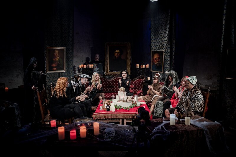 Alle Teilnehmenden versammeln sich im dekorierten Set, während Aria Addams die nächste Phase der Challenge einleitet und beide Teams sich vorbereiten. – Bild: ZDF und Sascha Vojticsek