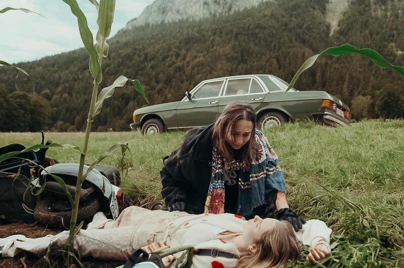 Dr. Martin Gruber wird Zeuge, wie Lexi Helmig (Mascha Schrader, kniend) und ihre Schwester Flora (Saskia Golinelli, liegend) mit der Vespa stürzen. – Bild: ZDF und Simon Zeller