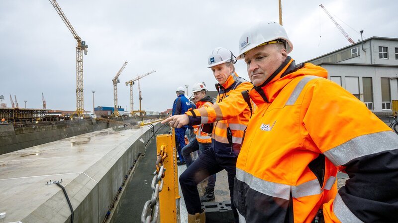 Zum letzten Mal können die Tunnel-Elemente im Trockenen von Dockmeister Tim Cappelmann (r.) und Teilprojektleiter Niek Huppes (r.) begutachtet werden. – Bild: NDR/Eric Shambroom Zum letzten Mal können die Tunnel-Elemente im Trockenen von Dockmeister Tim Cappelmann (r.) und Teilprojektleiter Niek Huppes (r.) begutachtet werden. – Bild: NDR/Eric Shambroom