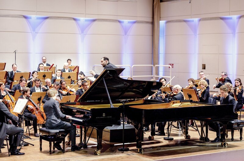 Unter der Leitung von Andris Nelsons (Mi.) proben die Pianisten Lucas (li.) und Arthur (re.) Jussen mit dem Leipziger Gewandhausorchester. – Bild: Holger Jacoby