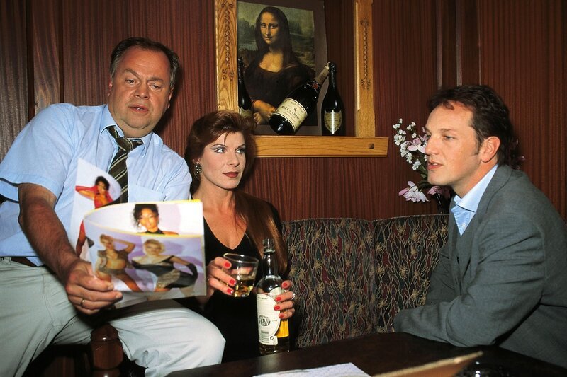 Mathilda (Claudia Wenzel) wird von den beiden Kommissaren Kehler (Wolfgang Bathke, l.) und Bongartz (Max Gertsch) befragt, ob sie dich an Gerlach erinnern kann. – Bild: RTL Deutschland