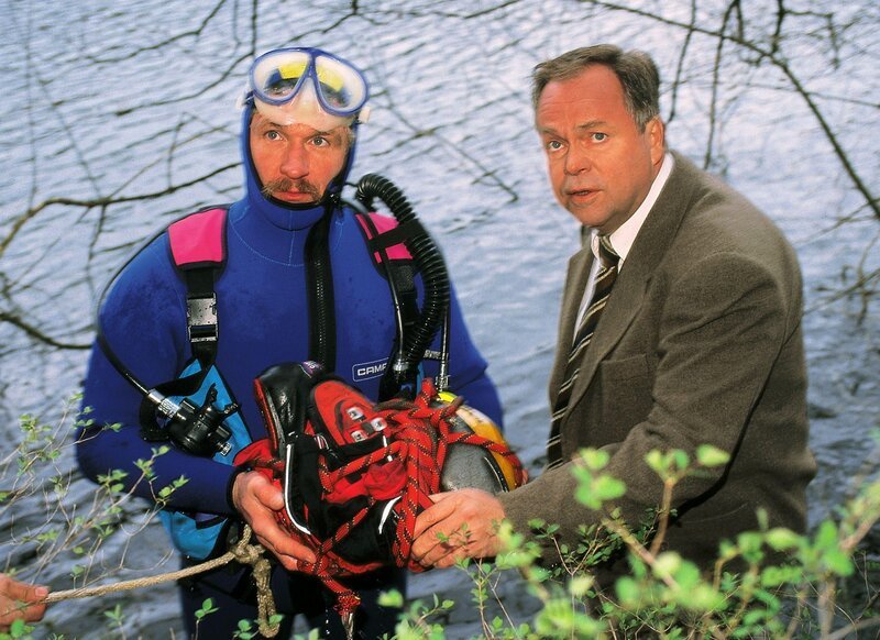 Die Polizei hat einen toten Jungen im Wasser gefunden. Kriminalhauptkommissar Stefan Kehler (Wolfgang Bathke, re.) spricht mit einem Taucher (Komparse) über die Beweissicherung. – Bild: RTL Deutschland