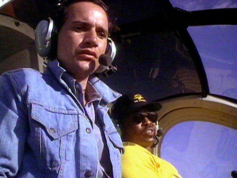 T.C. (Roger E. Mosley, re.) schmuggelt seinen alten Freund Joey (Vincent Caristi) mit dem Helicopter zurück nach Hawaii. – Bild: Super RTL